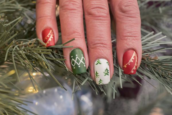unghie natalizie semplici con smalto rosso, verde e bianco, decorazioni dorate e alberi di Natale